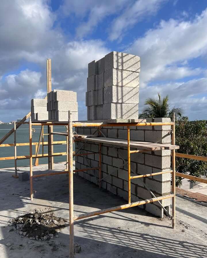 Skilled masonry contractors building a structural block wall in Miami-Dade County.